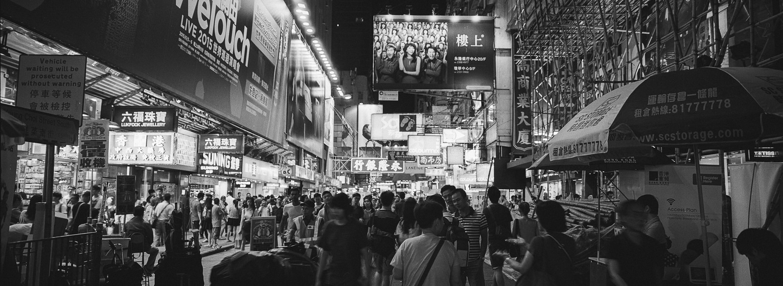 Pedestrians on street lined with shops in Hong Kong